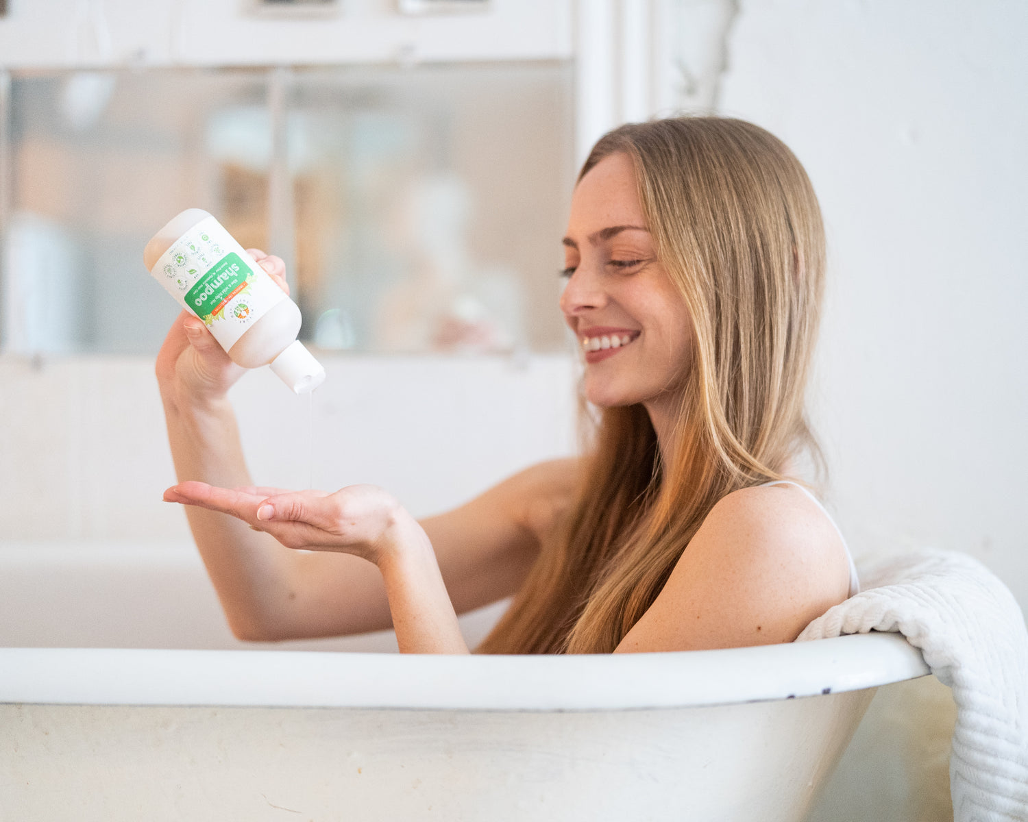 Woman having a bath using organic Nature Sustained natural Shampoo.